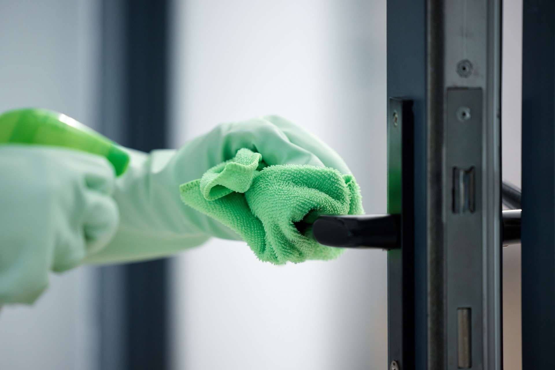 Shot of a woman wiping down the handles on her door